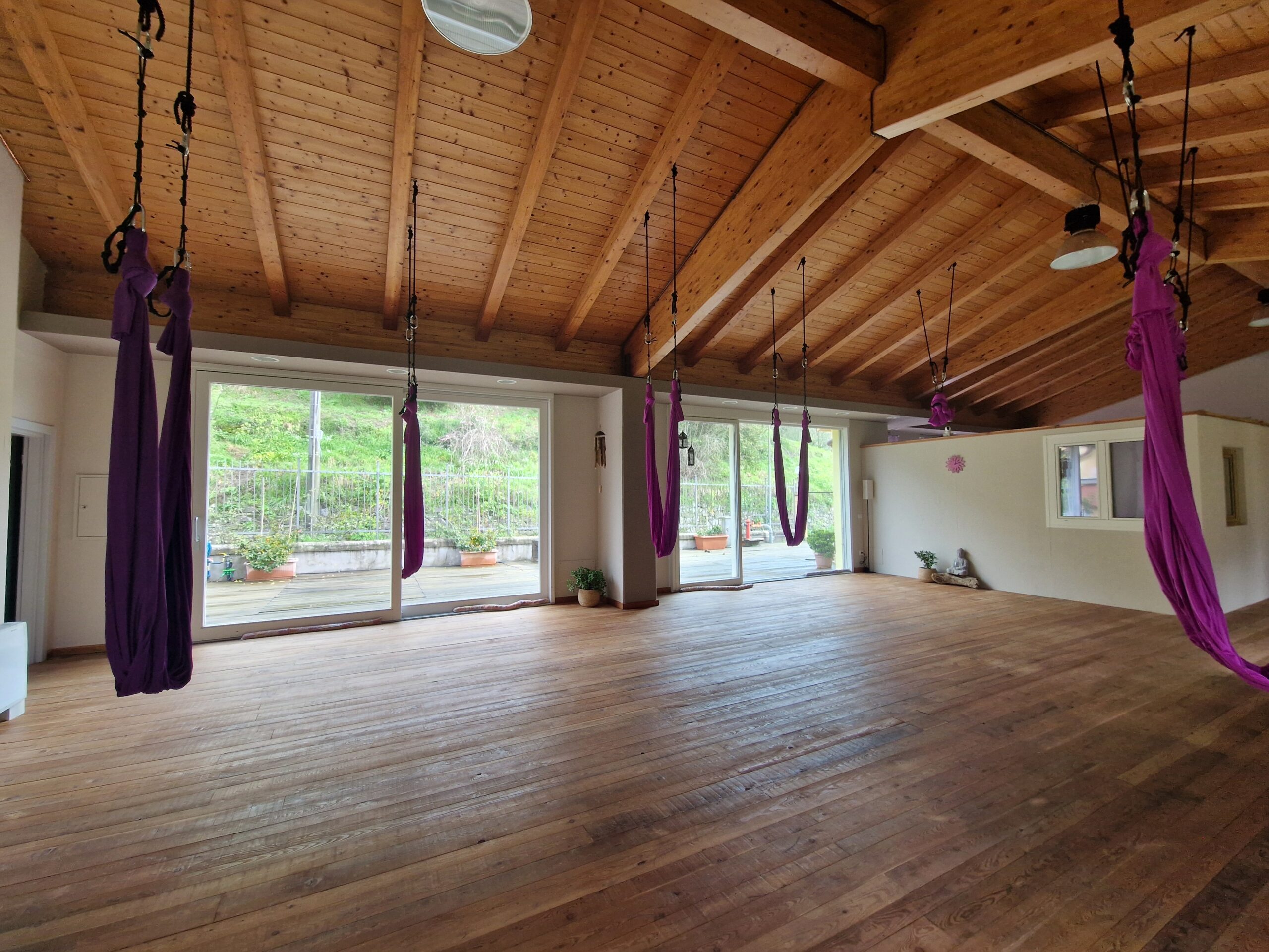 Sala yoga con travi in legno e vetrate sul verde a Chiavari - Il Sentiero dello Yoga