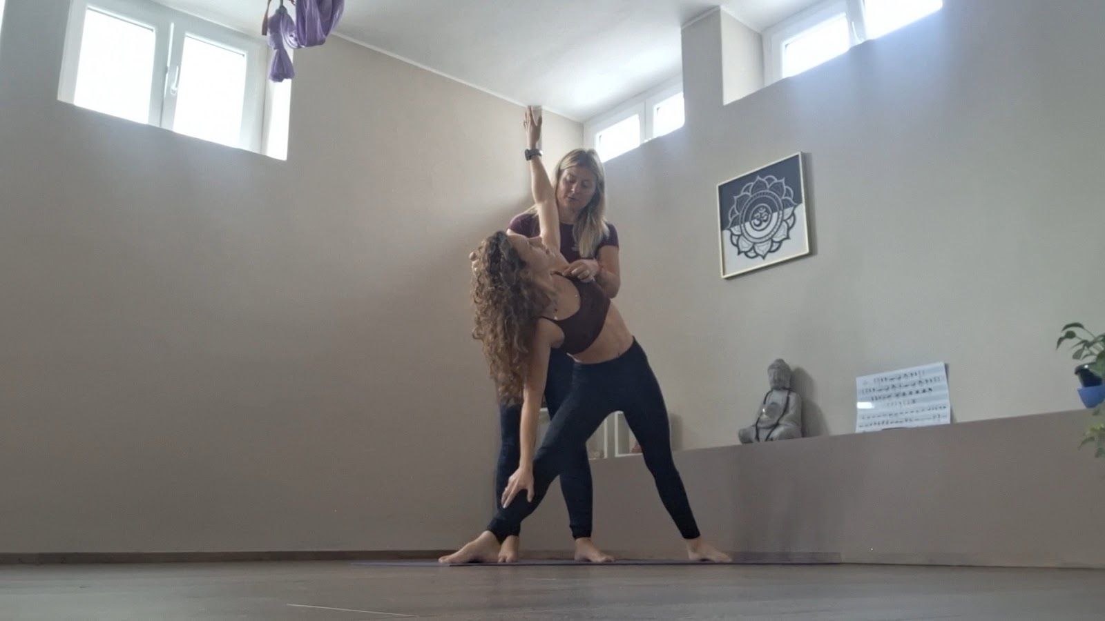 Valentina accompagna un'allieva durante una lezione di yoga a Bresso